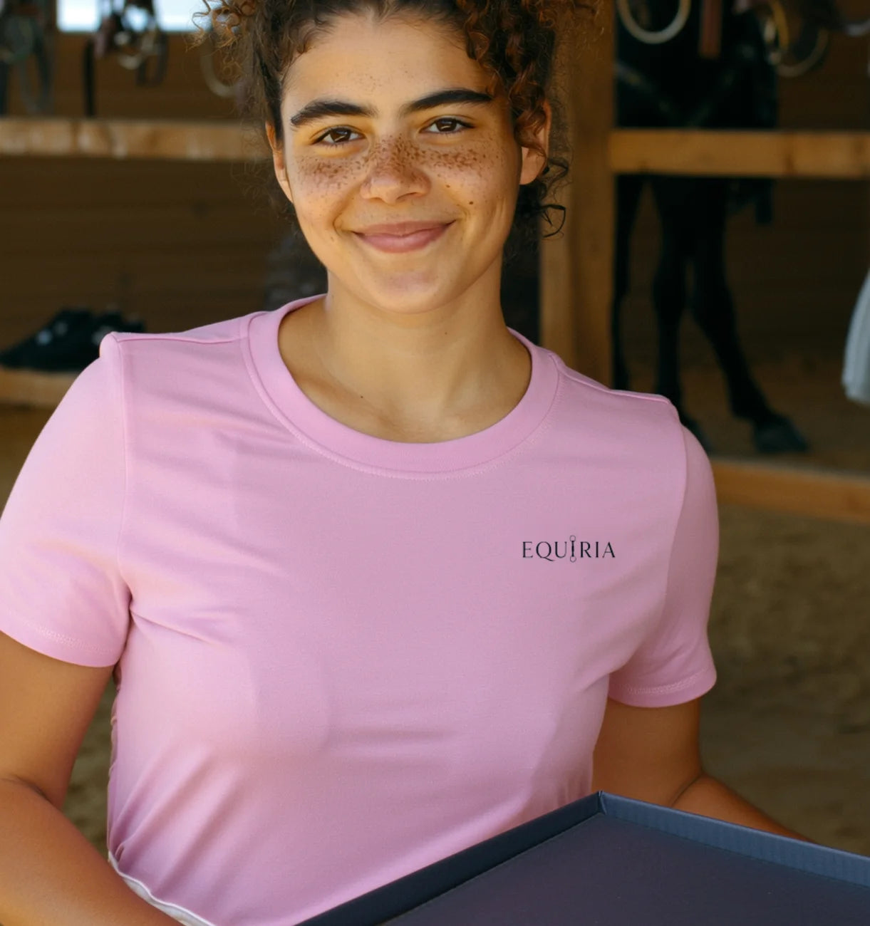 Amazzone sorridente che apre la scatola Equiria in scuderia